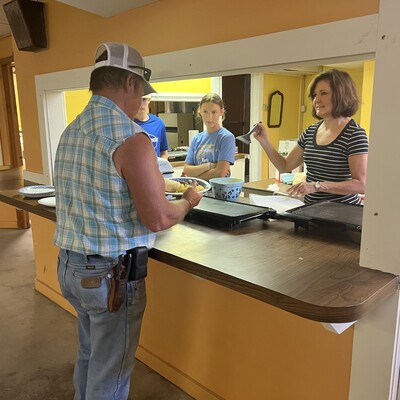 LLCPS Board Chairman, Cheryl Mussatto, serving up pancakes to Donnie Platz