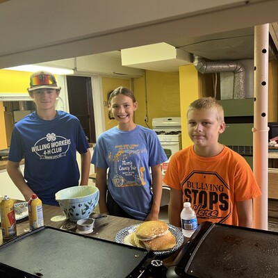 White City Willing Workers 4-H Club members helped serve, L to R: Jacob Kasten, Lilliana Stilwell, and Latimer resident, Blake Calvert.