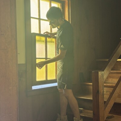 Linus placing sash on a small front window